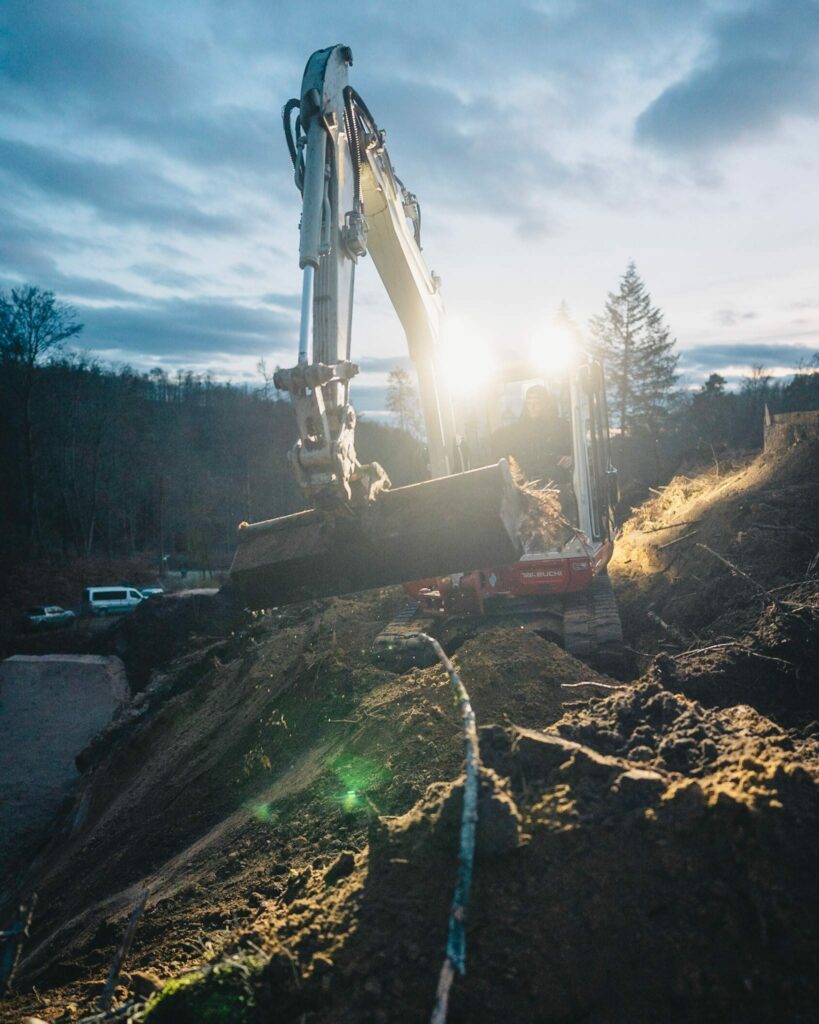 Trailbau mit einem Bagger im Wald